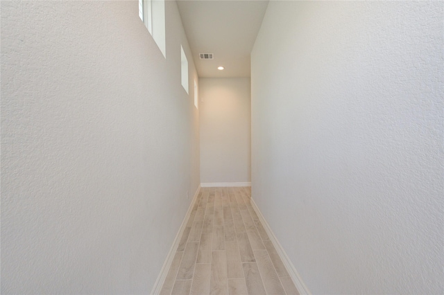 hall featuring baseboards, wood finish floors, recessed lighting, and visible vents