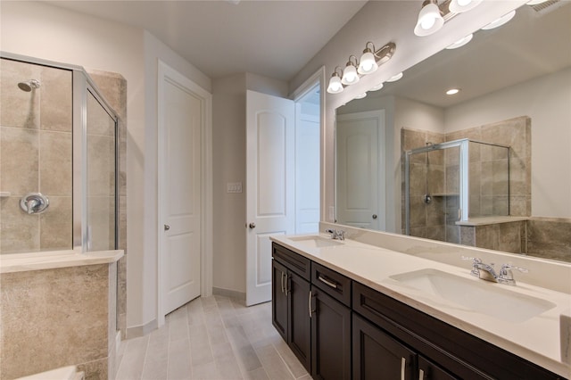 full bathroom featuring a sink, a shower stall, double vanity, and visible vents