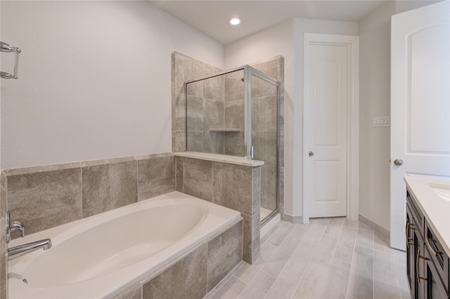 full bathroom featuring recessed lighting, a shower stall, a garden tub, and vanity
