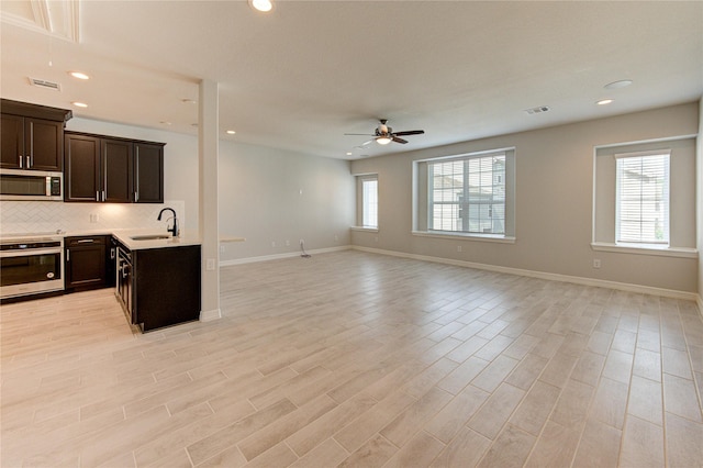 kitchen with ceiling fan, appliances with stainless steel finishes, a sink, open floor plan, and visible vents