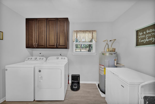 29133 E Lake Dr, Hempstead, TX 77445 - laundry room with baseboards, cabinet space, washing machine and clothes dryer, light wood-style flooring, and water heater