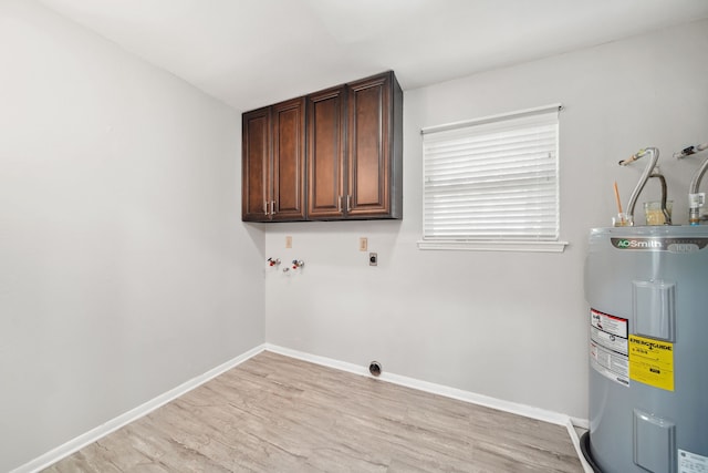 29133 E Lake Dr, Hempstead, TX 77445 - laundry room featuring hookup for an electric dryer, light wood-style flooring, cabinet space, and electric water heater