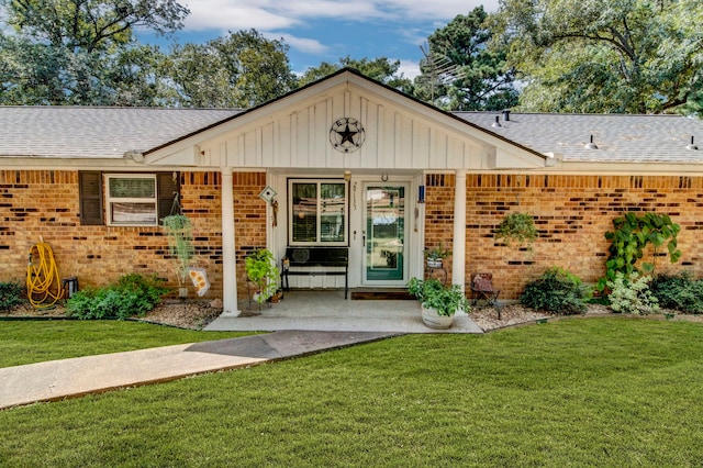 29133 E Lake Dr, Hempstead, TX 77445 - property entrance with brick siding, board and batten siding, roof with shingles, and a yard