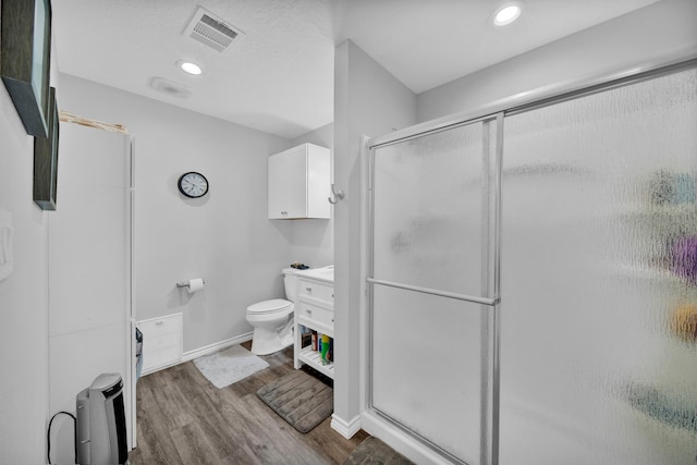 29133 E Lake Dr, Hempstead, TX 77445 - full bathroom featuring toilet, baseboards, wood finished floors, visible vents, and a stall shower