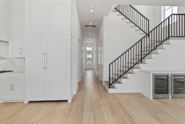 11365 Beachside Dr, Galveston, TX 77554 - foyer entrance featuring light wood finished floors, stairs, recessed lighting, beverage cooler, and baseboards