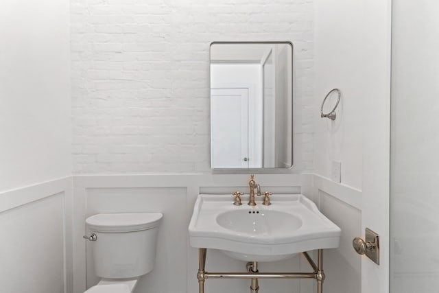 11365 Beachside Dr, Galveston, TX 77554 - bathroom with toilet, a sink, and a decorative wall