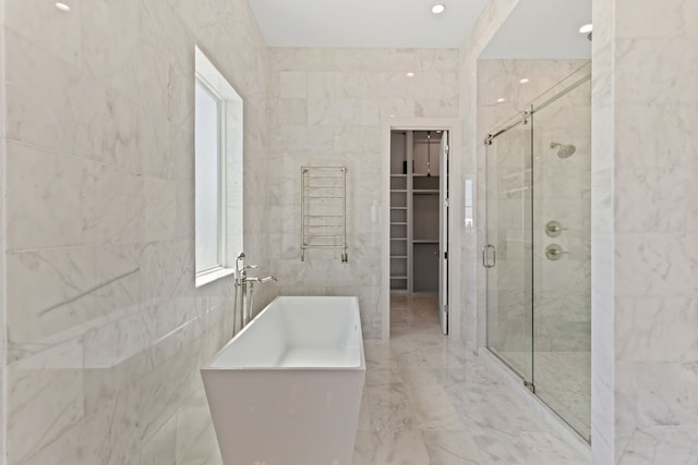 11365 Beachside Dr, Galveston, TX 77554 - full bathroom featuring a stall shower, tile walls, marble finish floors, a towel warming rack, and a freestanding bath
