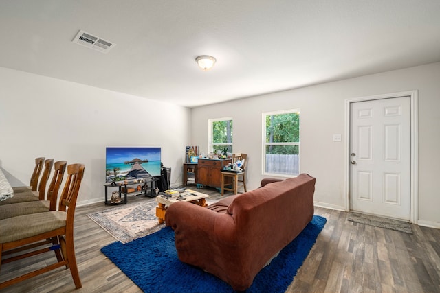 living room featuring baseboards, wood finished floors, and visible vents