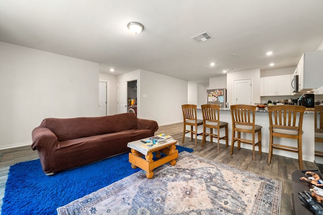 living room with recessed lighting, baseboards, visible vents, and wood finished floors
