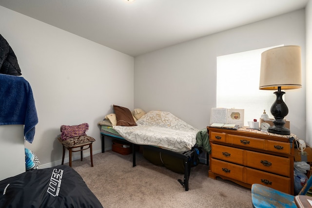 bedroom featuring baseboards and light colored carpet
