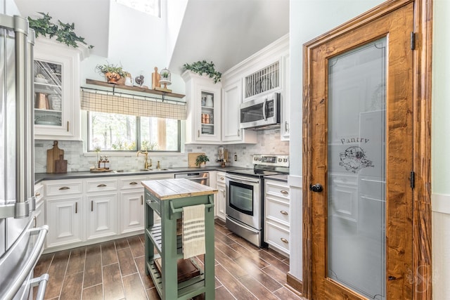 kitchen with a sink, white cabinetry, tasteful backsplash, and stainless steel appliances