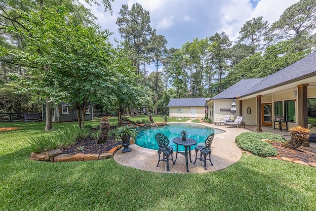 pool featuring an outdoor structure, a lawn, and a patio