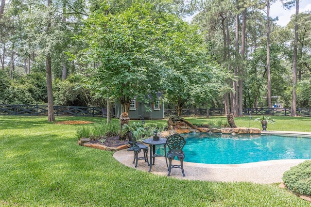 outdoor pool featuring a fenced backyard, an outdoor structure, and a yard