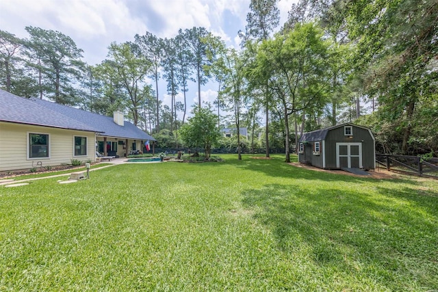 view of yard with a fenced in pool, a fenced backyard, an outbuilding, and a storage shed