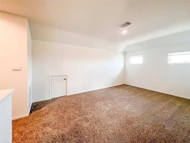additional living space featuring carpet floors, baseboards, and visible vents