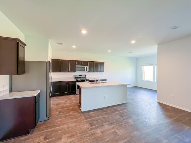 kitchen featuring light countertops, stainless steel appliances, a sink, and light wood-type flooring