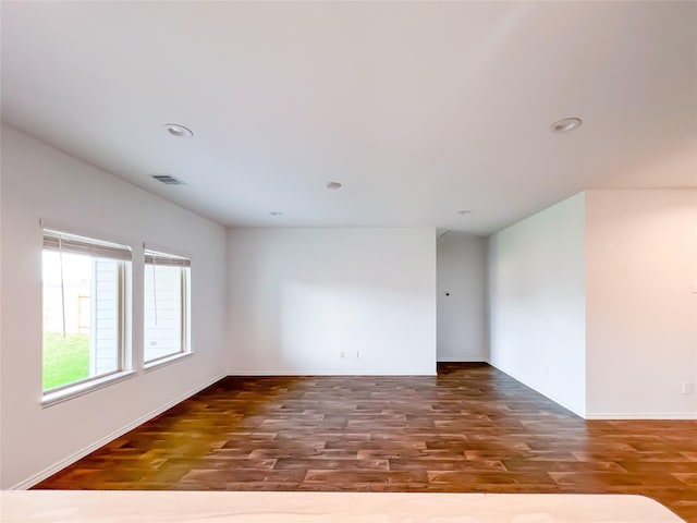 empty room with recessed lighting, baseboards, visible vents, and wood finished floors