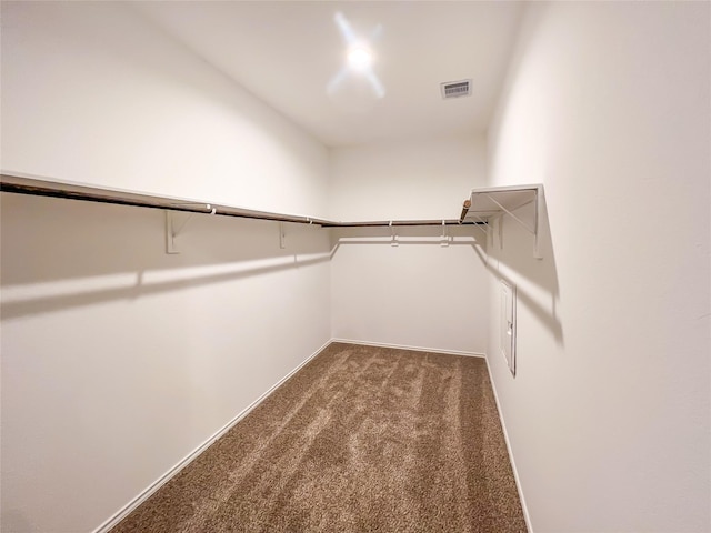 walk in closet featuring visible vents and dark colored carpet