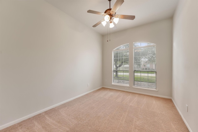 empty room featuring baseboards, light carpet, and ceiling fan