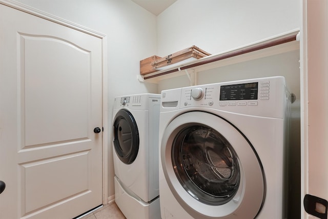 laundry room with washer and dryer, laundry area, and light tile patterned floors