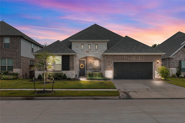 1017 Goose Creek St, Webster, TX 77598 - french country inspired facade with concrete driveway, a garage, a front lawn, roof with shingles, and stone siding