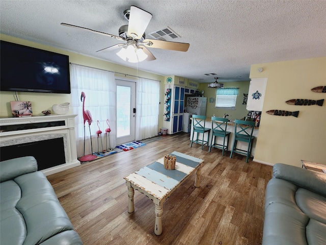 16607 Henry Morgan Rd, Jamaica Beach, TX 77554 - living area with a ceiling fan, a textured ceiling, visible vents, and wood finished floors