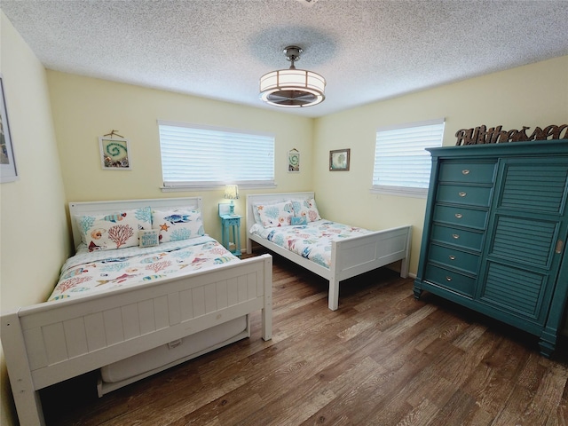 16607 Henry Morgan Rd, Jamaica Beach, TX 77554 - bedroom featuring dark wood-style flooring and a textured ceiling