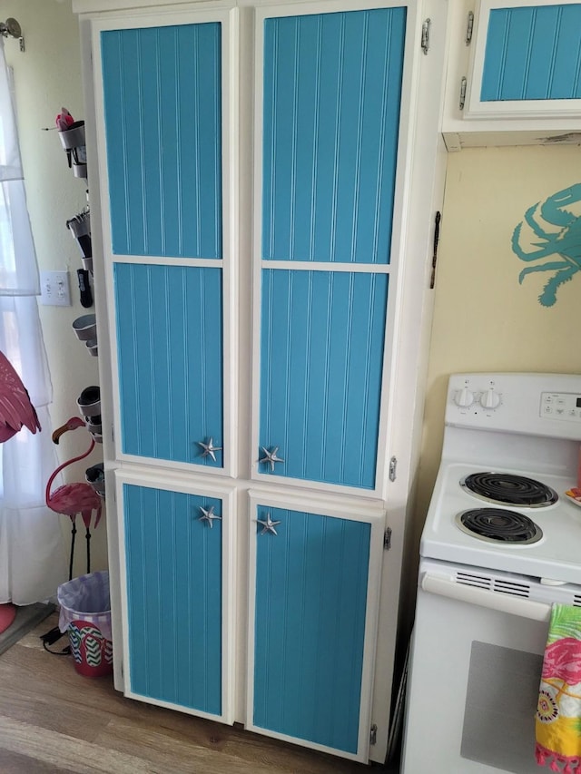 16607 Henry Morgan Rd, Jamaica Beach, TX 77554 - interior space with blue cabinets, electric range, and wood finished floors