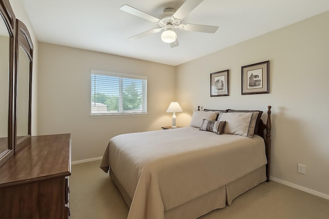 bedroom with a ceiling fan, baseboards, and light carpet