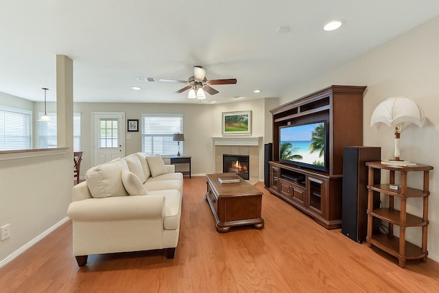 living area featuring baseboards, ceiling fan, light wood-type flooring, and visible vents
