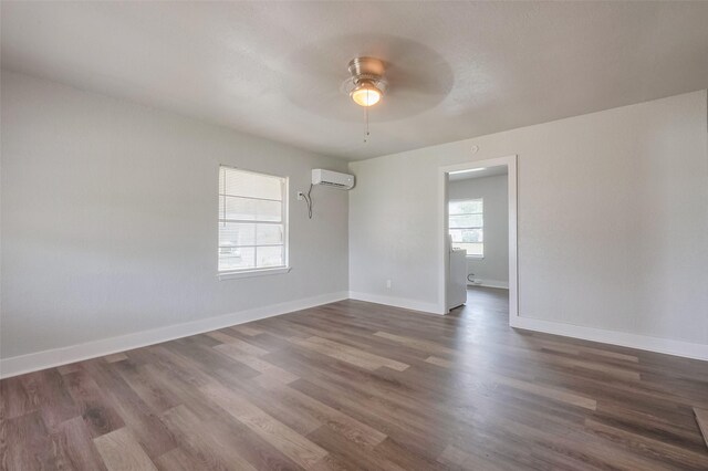 unfurnished room with baseboards, a wall mounted AC, a ceiling fan, and dark wood-type flooring