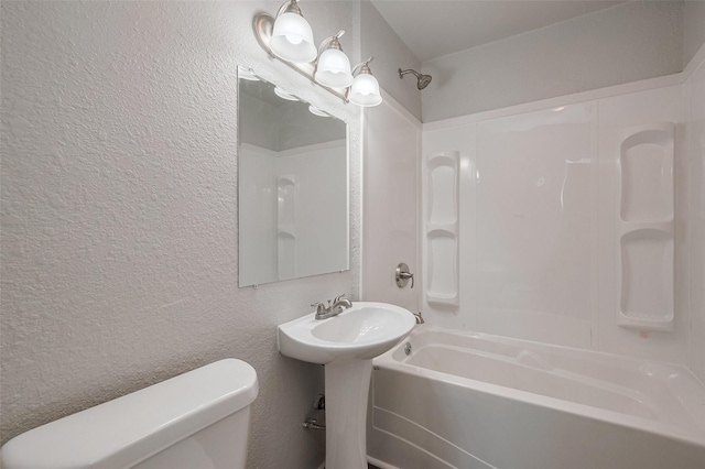 full bathroom featuring a textured wall, toilet, and shower / washtub combination