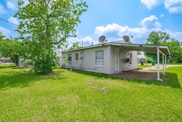 rear view of house with a lawn, cooling unit, driveway, and an attached carport