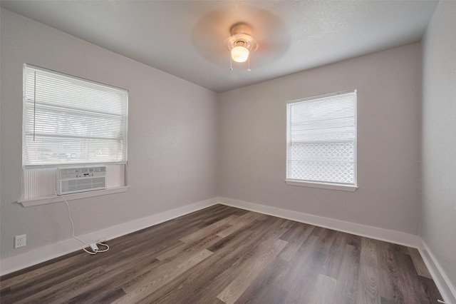 unfurnished room with ceiling fan, baseboards, dark wood finished floors, and a wealth of natural light