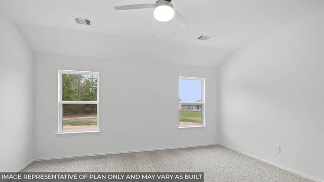 spare room with carpet flooring, a ceiling fan, visible vents, and a wealth of natural light