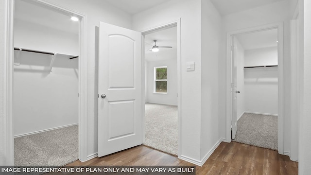 hall featuring baseboards, carpet, and wood finished floors