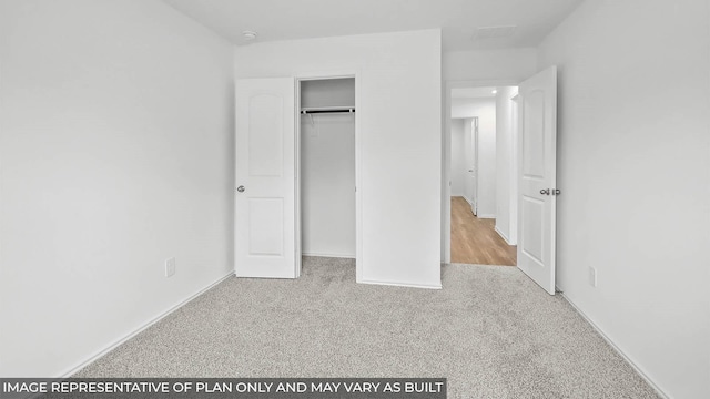 unfurnished bedroom with a closet, baseboards, and carpet flooring