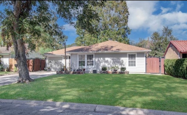 ranch-style house featuring fence, an attached garage, a front lawn, a gate, and concrete driveway