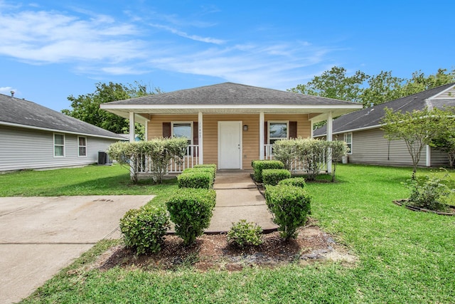 bungalow with a front lawn, roof with shingles, central air condition unit, and covered porch