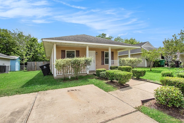 bungalow-style house featuring fence, central air condition unit, a porch, and a front lawn