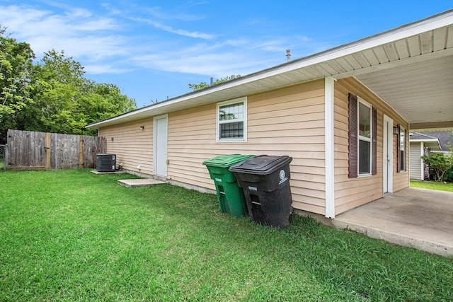 view of home's exterior featuring a lawn, central AC, fence, and a patio area