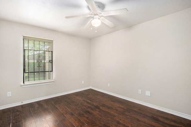 spare room featuring baseboards, a ceiling fan, and dark wood-style floors