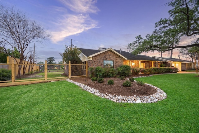 1033 Gardendale Dr, Houston, TX 77018 - property exterior at dusk featuring a lawn, brick siding, and fence