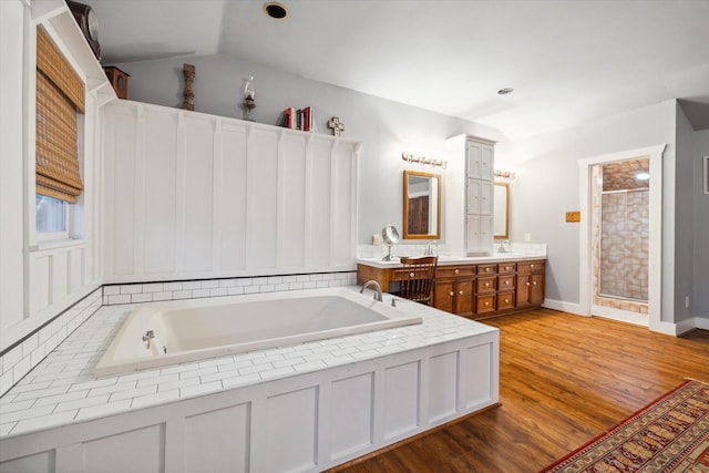 1033 Gardendale Dr, Houston, TX 77018 - bathroom featuring double vanity, wood finished floors, a bath, a shower stall, and vaulted ceiling