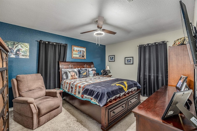carpeted bedroom with a textured wall, a ceiling fan, and a textured ceiling