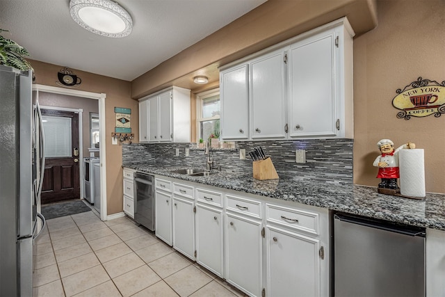 kitchen with light tile patterned flooring, white cabinets, a sink, backsplash, and stainless steel appliances