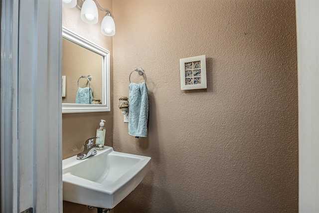 bathroom featuring a textured wall and a sink