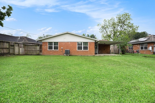 rear view of house featuring a lawn, brick siding, cooling unit, and a fenced backyard