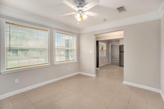 empty room featuring a ceiling fan, baseboards, light tile patterned floors, visible vents, and ornamental molding
