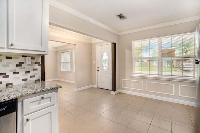 foyer featuring crown molding, visible vents, plenty of natural light, and light tile patterned floors